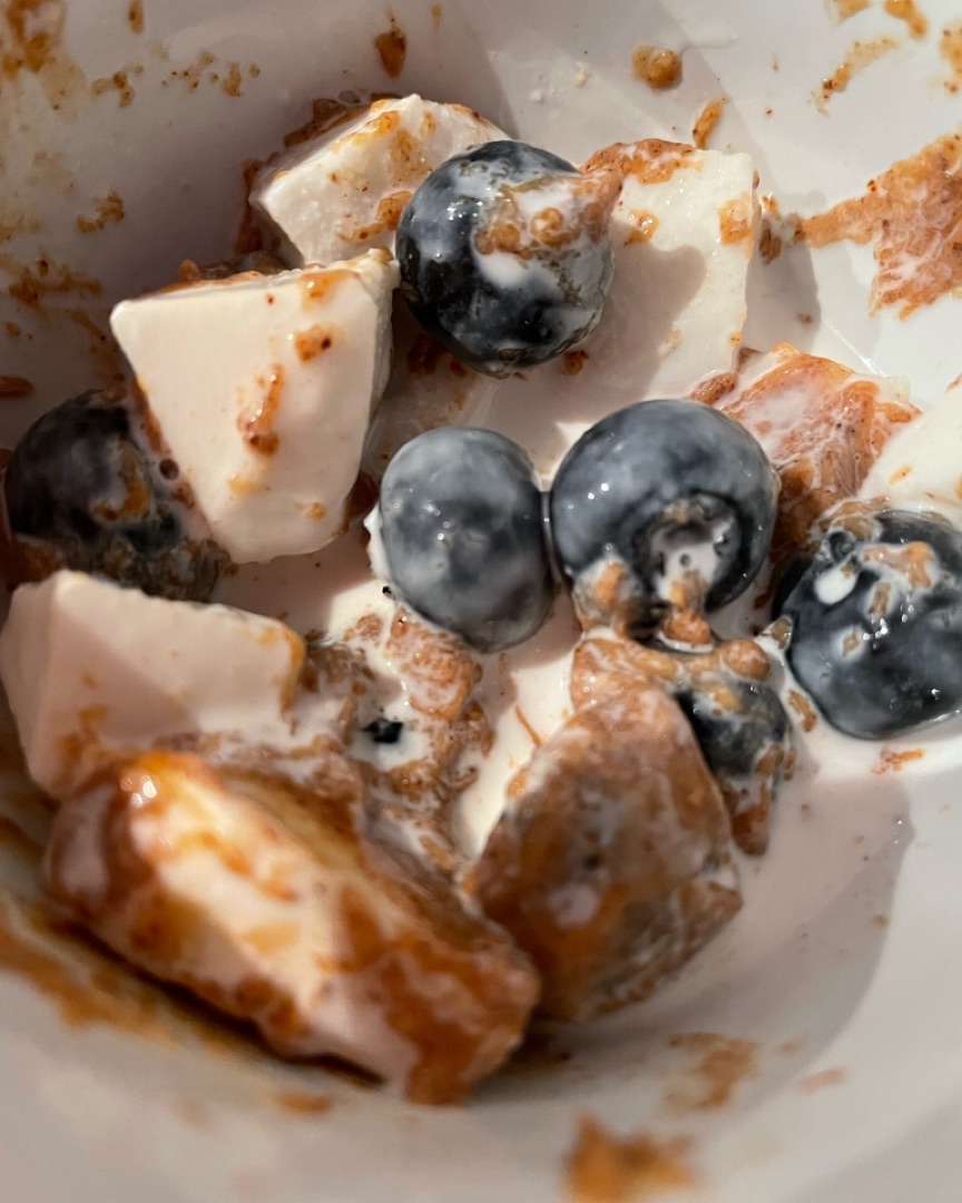 Merienda bol con arándanos, coco, crema de almendras y bebida vegetal de coco. 