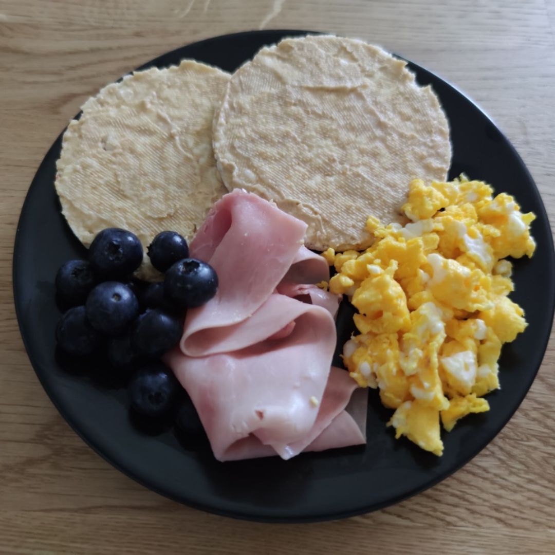Tortitas de arroz con hummus, huevo revuelto, jamón y arándanos Tortitas de arroz con hummus, huevo revuelto, jamón y arándanos