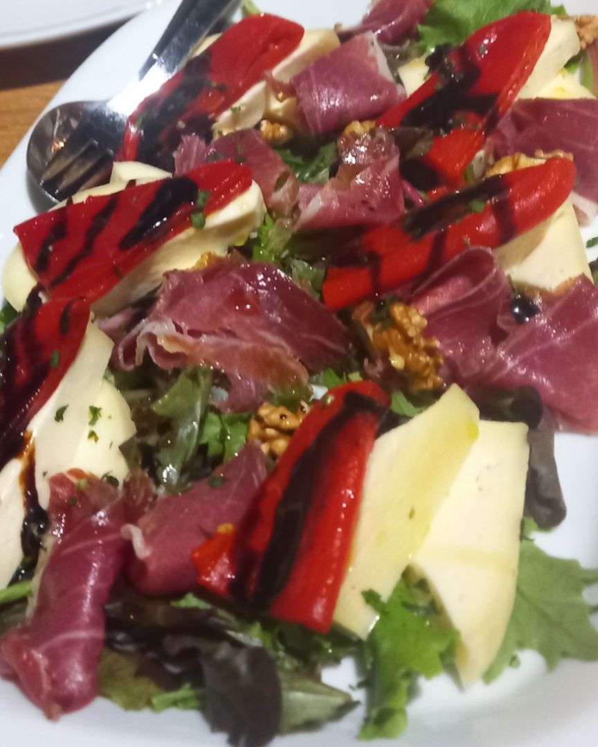 Ensalada de queso, pimiento, jamón y frutos secos.