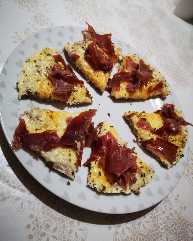 Pizza con base de clara de huevo y atún, con llema esparcida por encima, queso y jamón Pizza con base de clara de huevo y atún, con llema esparcida por encima, queso y jamón