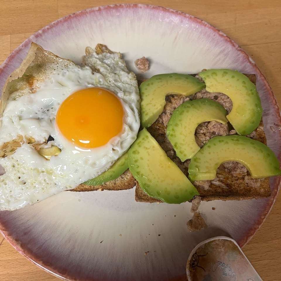 Pan de cereales con base de atún, rodajas de guacamole y huevo a la plancha Pan de cereales con base de atún, rodajas de guacamole y huevo a la plancha