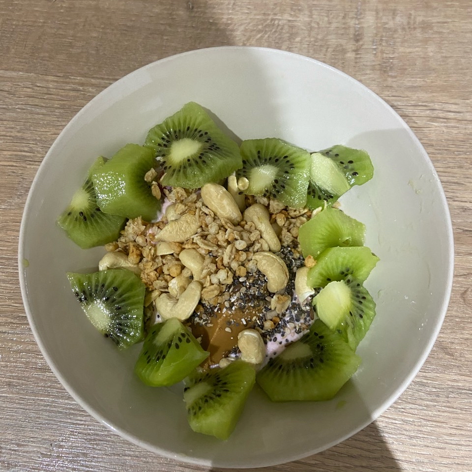 Yogur de proteínas con fruta, crema de cacahuete, anacardos, muesli y semillas Yogur de proteínas con fruta, crema de cacahuete, anacardos, muesli y semillas