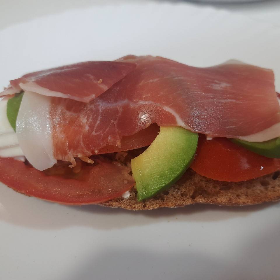 Tostada de pan integral, tomate, aguacate , queso fresco y jamón.
