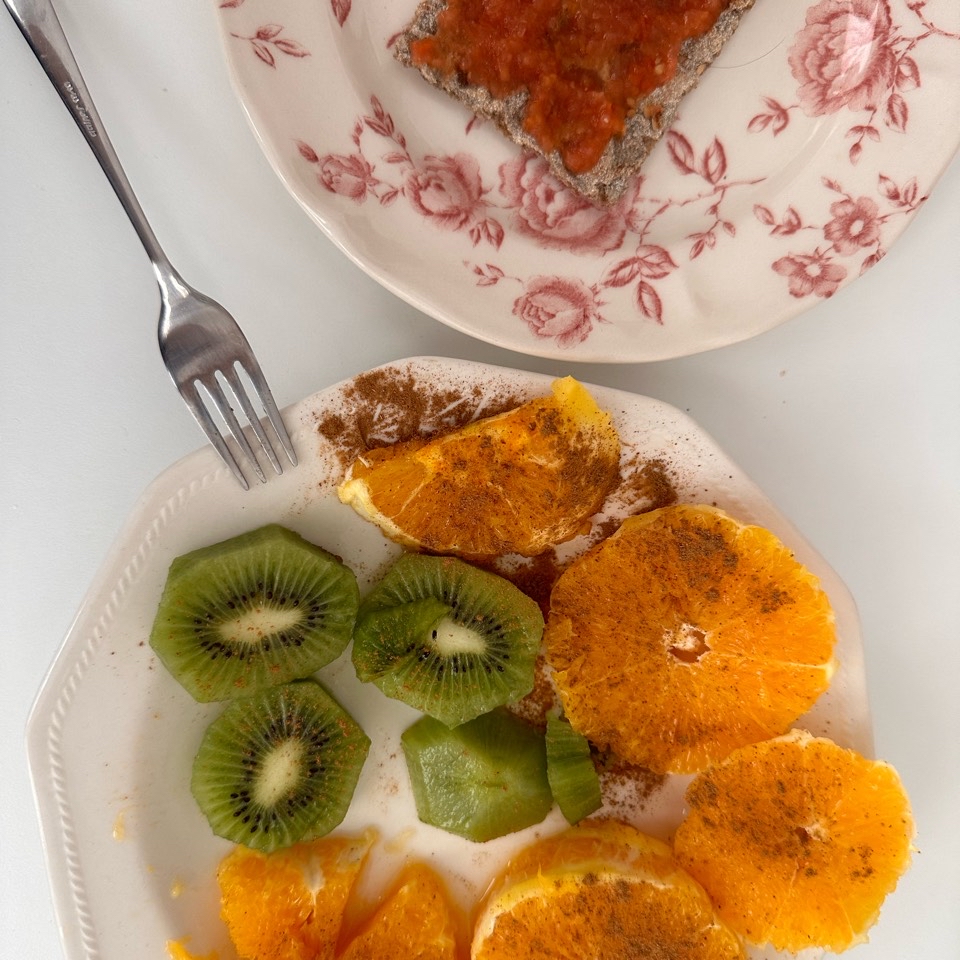 Naranja y kiwi con canela en polvo y tostadas con tomate Naranja y kiwi con canela en polvo y tostadas con tomate